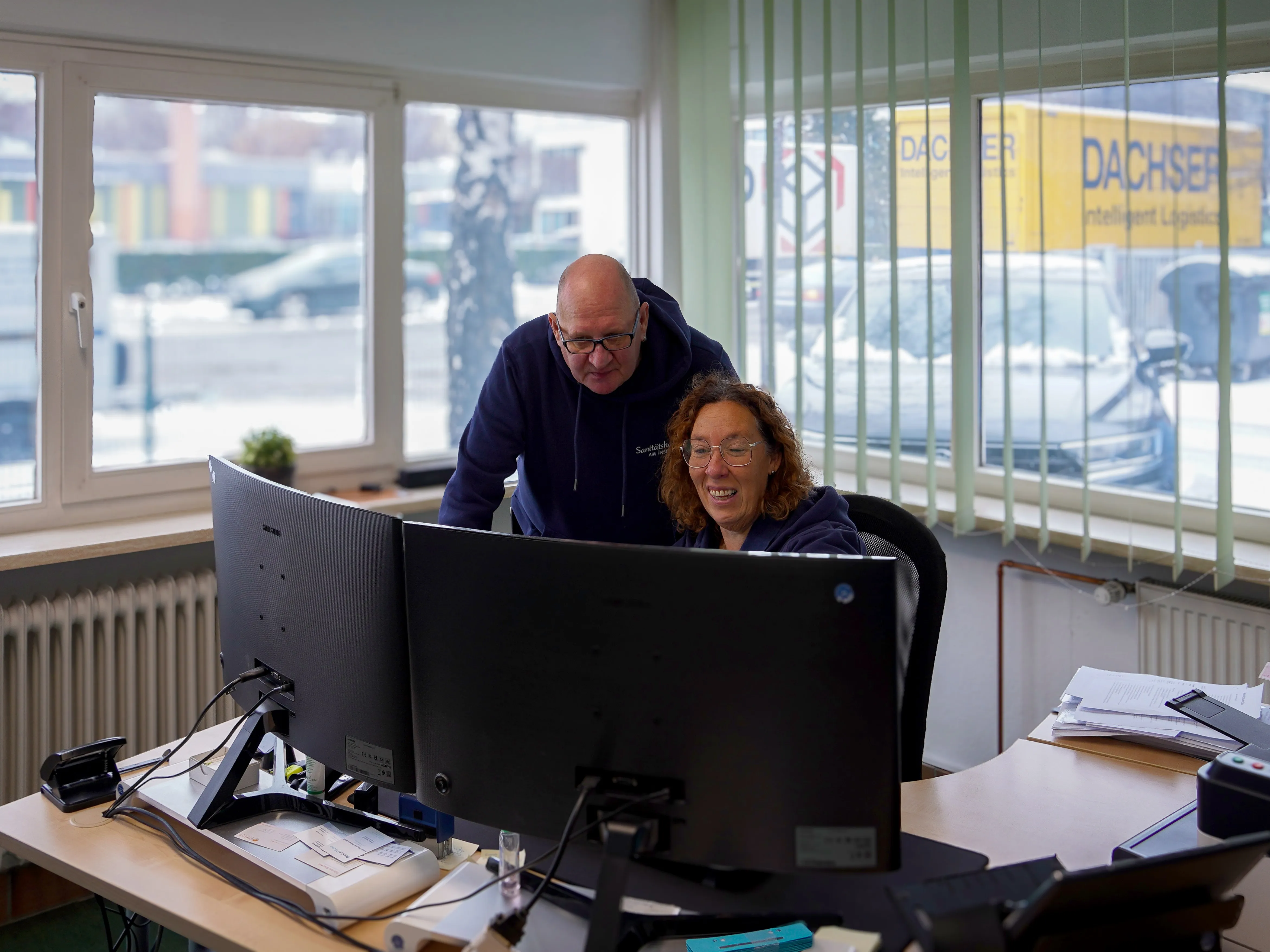 Zwei Kolleg:innen besprechen sich gemeinsam am Bildschirm – verlässliche Zusammenarbeit im Team des Sanitätshaus Kutschke.